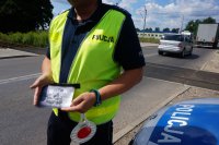 policjant trzyma ulotki kampanii Bezpieczny przejazd