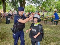 Na zdjęciu dziecko przymierza specjalny policyjny mundur.