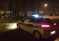Na zdjęciu policyjny radiowóz stojący w rejonie cmentarza w Lublińcu w porze wieczornej.