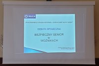 Na zdjęciu slajd prezentacji mówiący o temacie spotkania - Bezpieczny senior w Woźnikach.