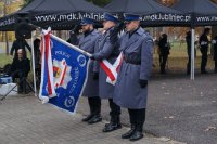Na zdjęciu policjanci ze sztandarem oddają honor przed pomnikiem pochylając sztandar.