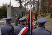 Na zdjęciu sztandar KPP Lubliniec na tle pomnika, obok stojący harcerze i żołnierze.