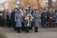 Na zdjęciu kierownictwo KPP Lubliniec przed złożeniem kwiatów pod pomnikiem, trzech umundurowanych policjantów , środkowy trzyma kwiaty.