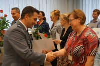 Na zdjęciu komendant KPP Lubliniec wręcza kobiecie kwiaty i list gratulacyjny.
