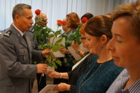 Na zdjęciu zastępca komendanta KPP Lubliniec wręcza kwiaty pracownikom cywilnym.