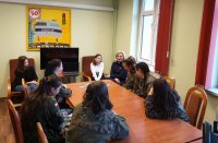 Na zdjęciu uczestnicy dnia przedsiębiorczości siedzący w wojskowych mundurach przy stole a wraz z nimi funkcjonariuszka Zespołu Kadr i Szkolenia KPP Lubliniec.