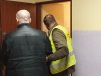 Na zdjęciu sprawca rozboju wprowadzany do pomieszczenia dla osób zatrzymanych w lublinieckiej Komendzie Policji.