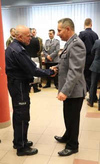 Na zdjęciu  uczestnicy pożegnania zastępcy komendanta powiatowego w Lublińcu. Odchodzący zastępca komendanta przyjmuje gratulacje.