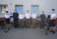 Na zdjęciu policjanci i przedstawiciele nadleśnictw w czasie przekazania 3 rowerów.