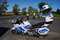 Na zdjęciu policyjny motocykl i radiowóz w trakcie akcji Dni Bezpieczeństwa w Ruchu Drogowym.