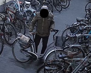 na zdjęciu widoczny jest mężczyzna trzymający rower , wokół niego  stoją inne rowery w stojakach